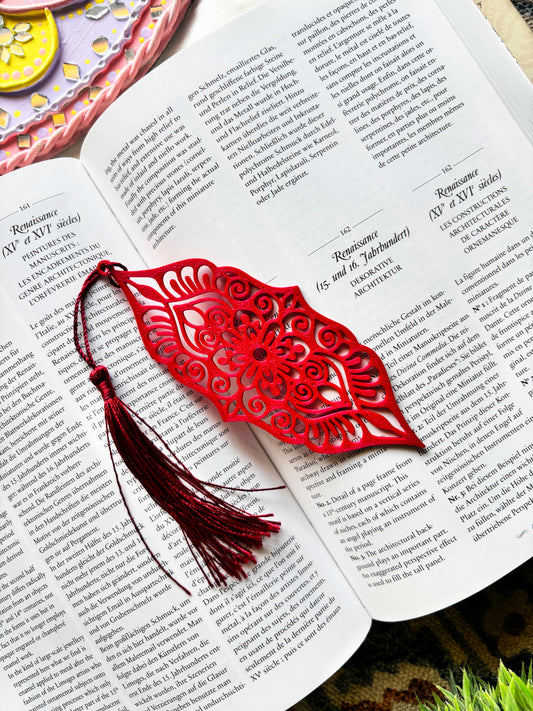 Red decorative bookmark with tassel on an open book